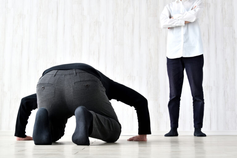 Man doing a deep apology dogeza bow to another man