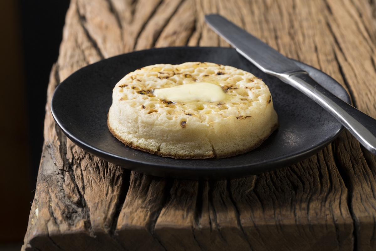 Toasted crumpets on a rustic wooden table.