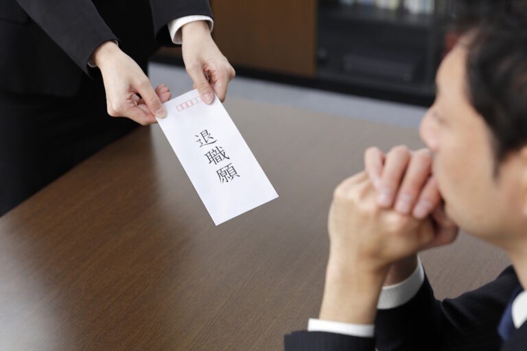 A woman handing her boss a letter of resignation