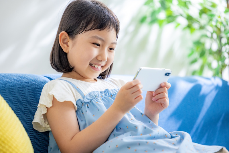 Young girl smiling at smartphone