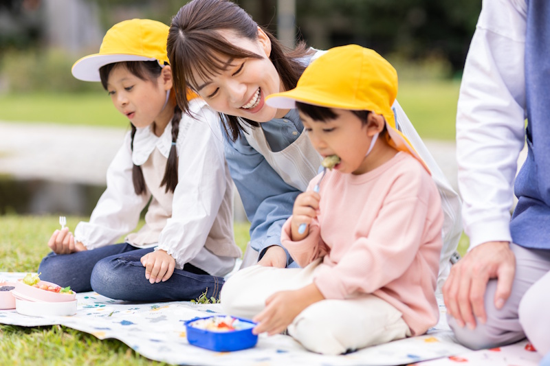 Picture of adult woman looking at a young child as she eats