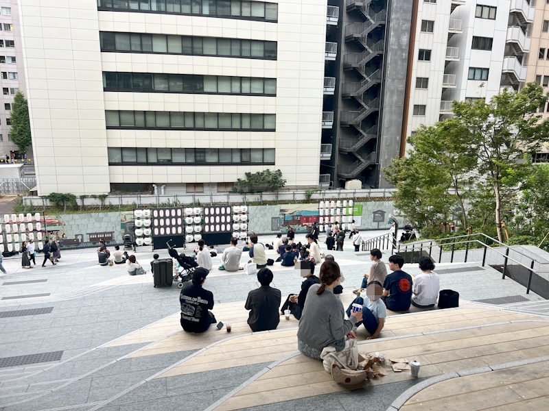 People sitting on steps near NeWoman