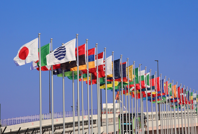 Line of different country's flags flying on staffs 