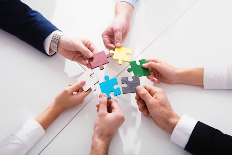 People working together to build a colored puzzle.