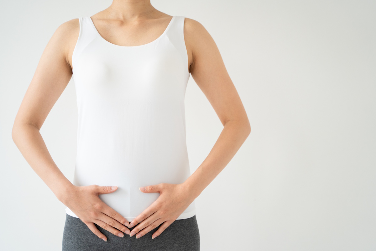 Woman framing her abdomen with both hands