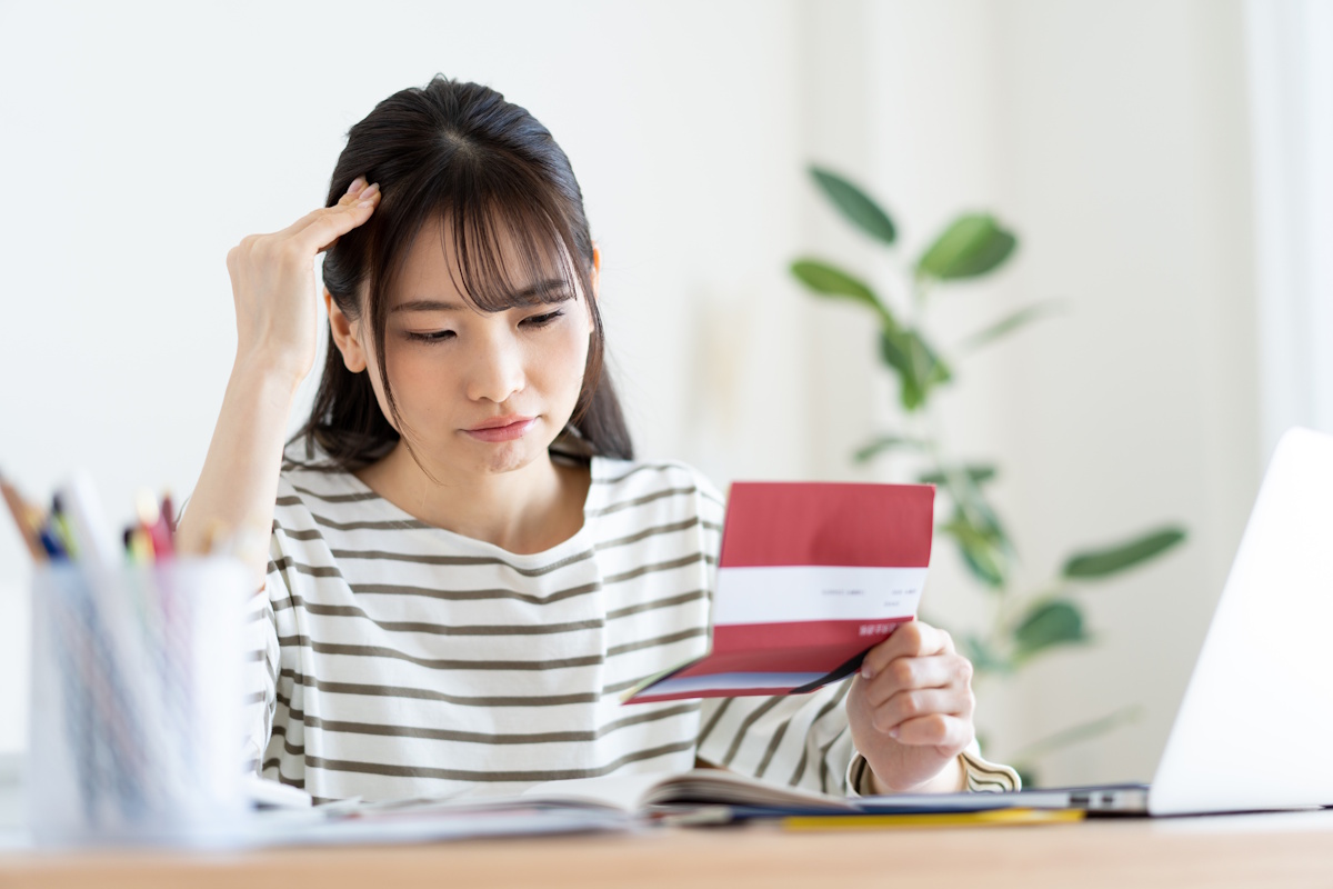 Woman looking in frustration at her checkbook