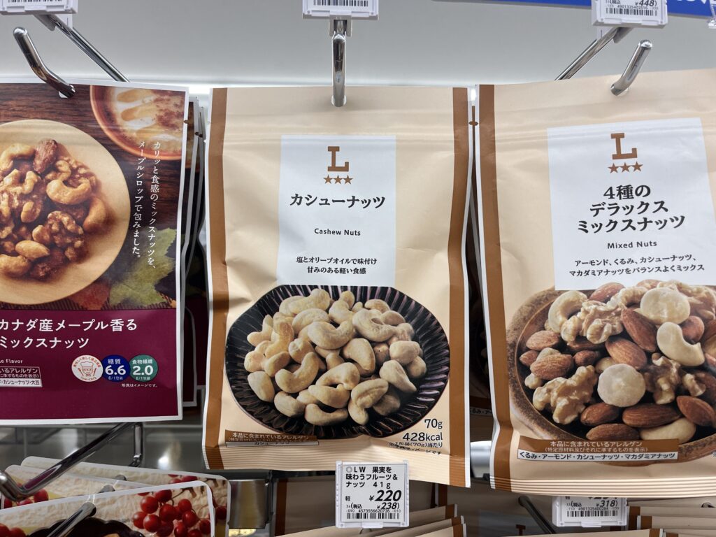 Bags of cashew nuts and mixed nuts on a convenience store shelf in Japan, with Japanese product labels.