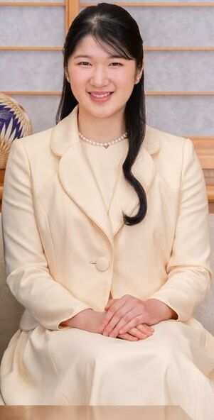Formal portrait of Aiko, Princess Toshi, seated and wearing a cream-colored suit and pearl necklace.