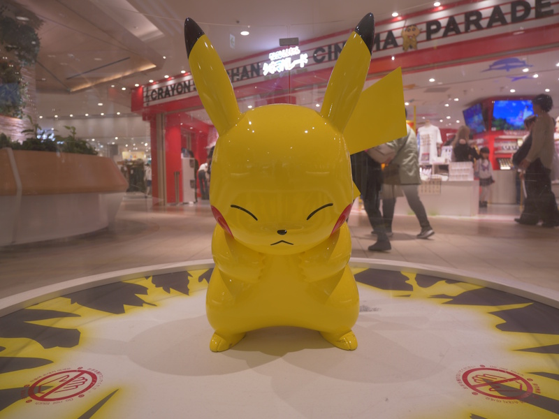 A large Pikachu statue with crossed arms on display at Tokyo's Pokemon Cinema Parade.