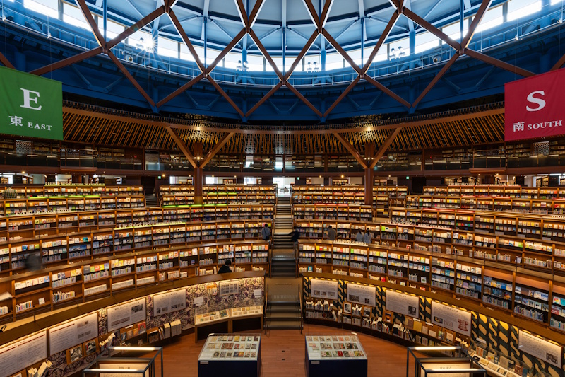 Interior of the Ishikawa Prefectural Library's Book Street atrium, with circular bookshelves under a domed lattice ceiling.