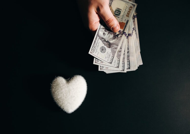 A man handing money in the direction of a heart-shaped object