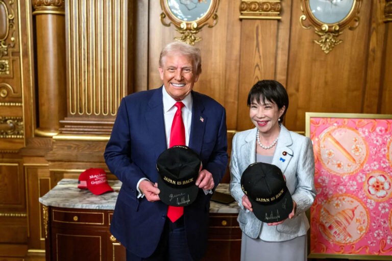 Donald Trump and Takaichi Sanae holding signed "Japan is Back" hats
