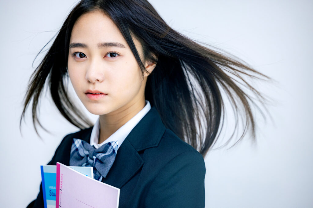 Japanese high school girl in uniform carrying textbooks