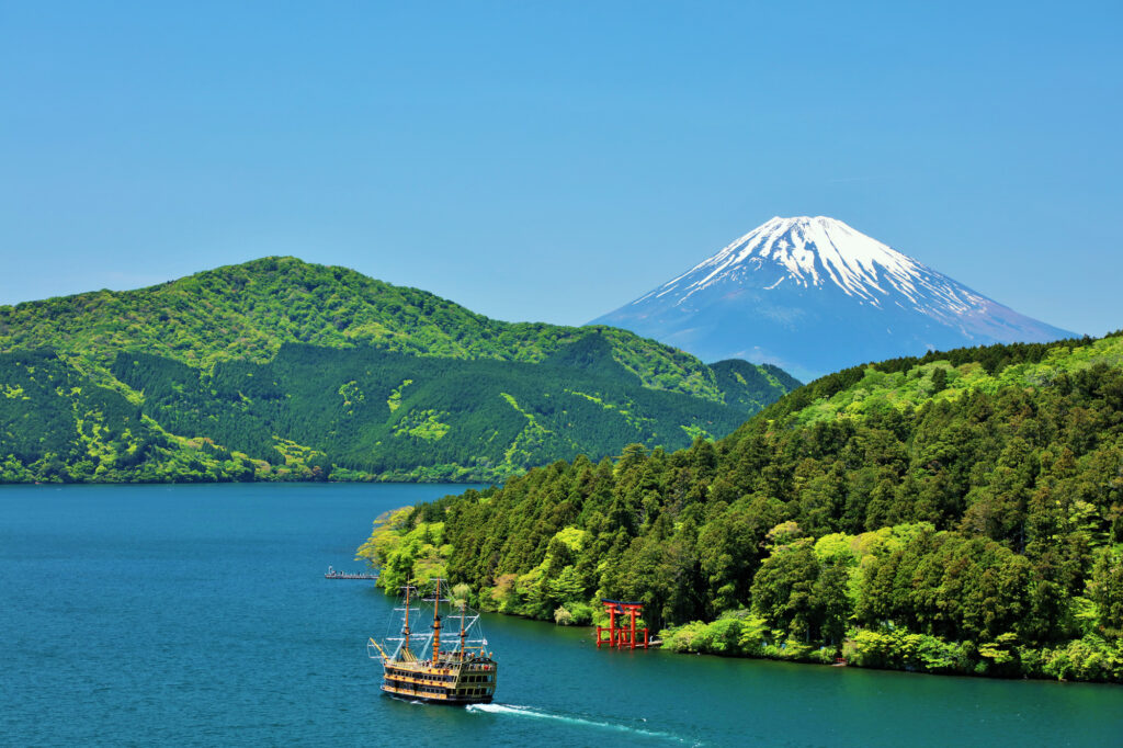 Lake Ashi in Hakone with a sightseeing boat, torii gate, and Mt. Fuji in the background