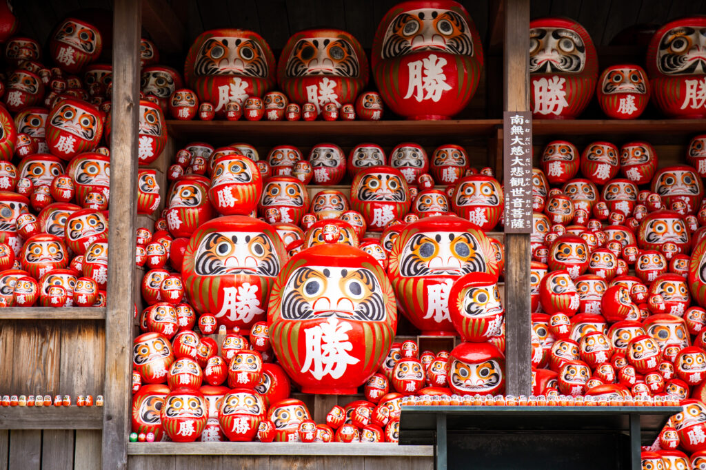 Rows of red Kachi-Daruma dolls marked with the kanji for victory at Katsuoji Temple