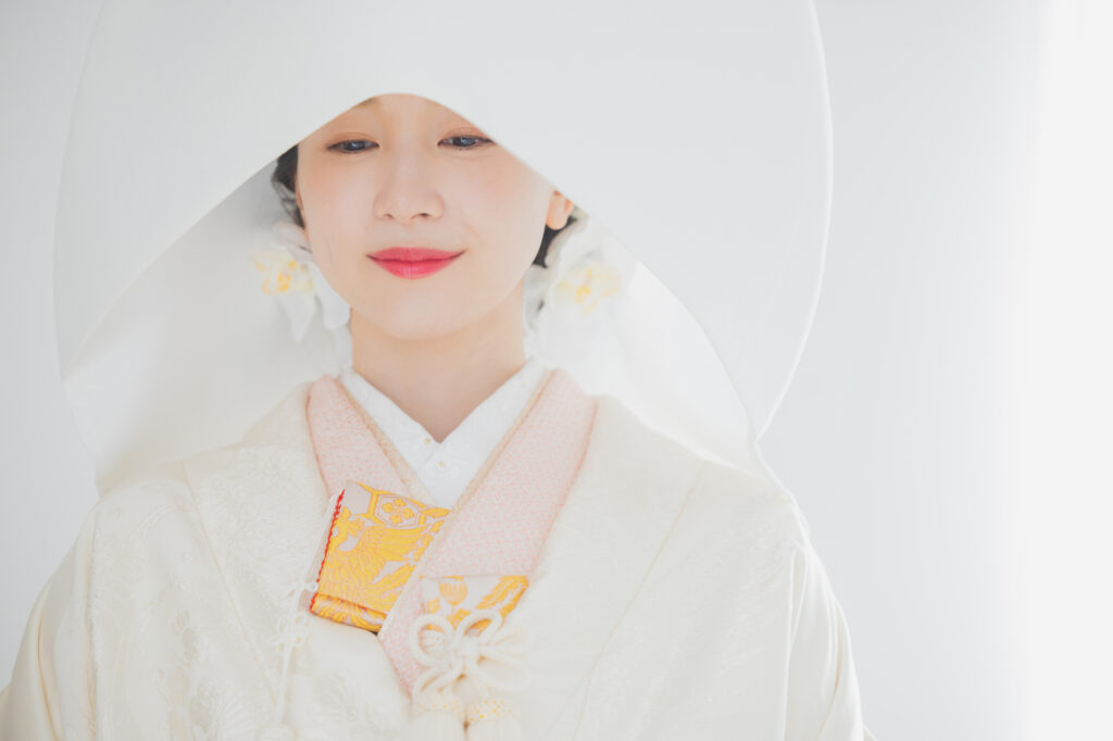Japanese woman wearing a white shiromuku kimono and traditional wataboshi headdress