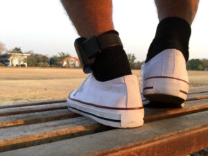Man in sneakers wearing a GPS ankle monitoring bracelet