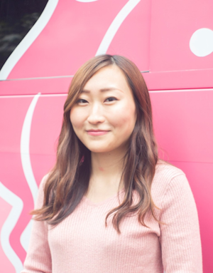 Nitō Yumeno, head of the support group Colabo, photographed in front of a pink wall