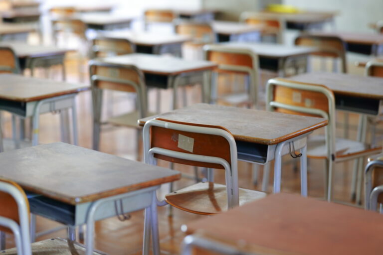 Empty wooden desks and chairs in a Japanese school classroom