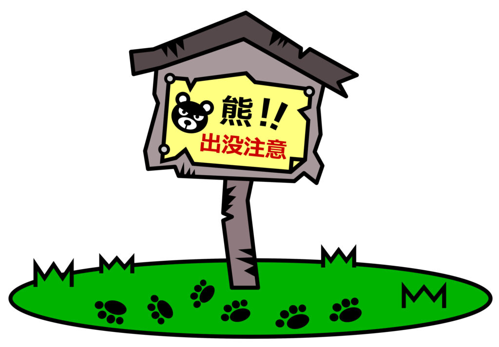 Cartoon roadside warning sign reading 熊!! 出没注意 (Bear! Beware) with a bear's face, above paw prints in the grass