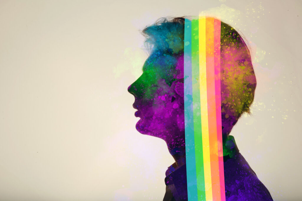 Double-exposure silhouette of a person in profile overlaid with rainbow colors