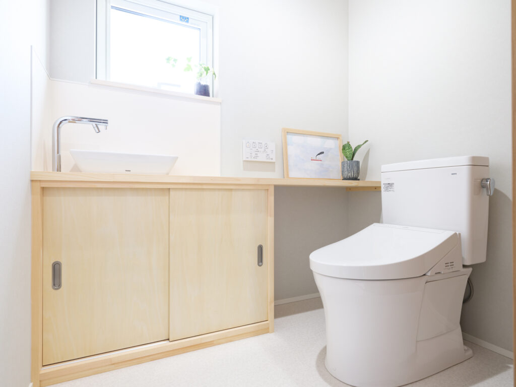 Modern Japanese toilet room with a bidet-seat toilet and wood cabinetry