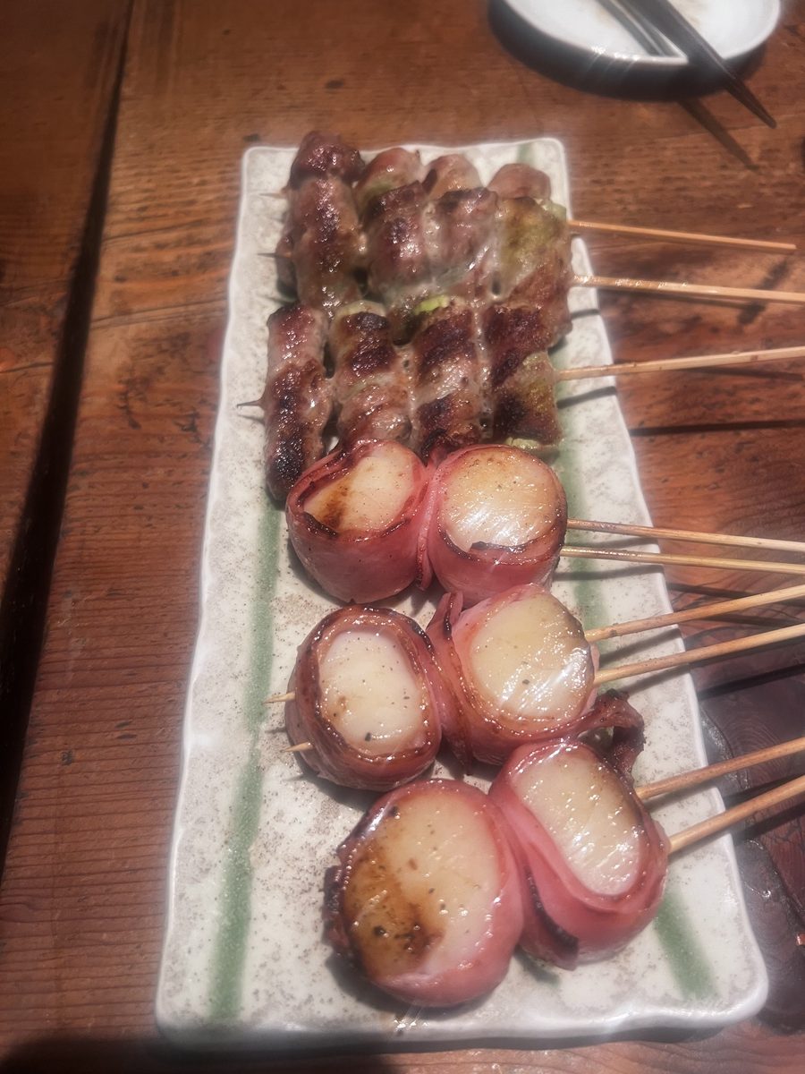 Bacon-wrapped scallop skewers on a plate