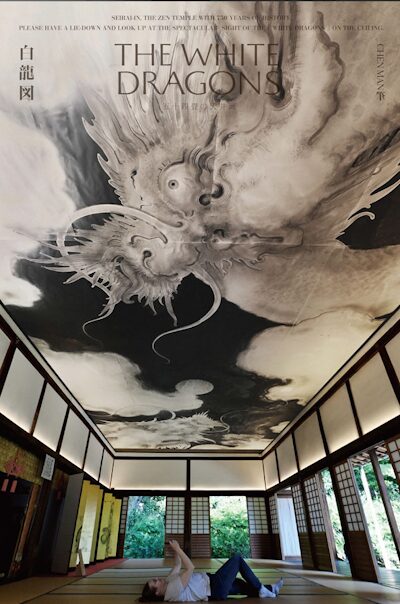 A visitor lies on the tatami floor to view Chen Man's white-dragon ceiling painting at Seiraiin, on a promotional poster