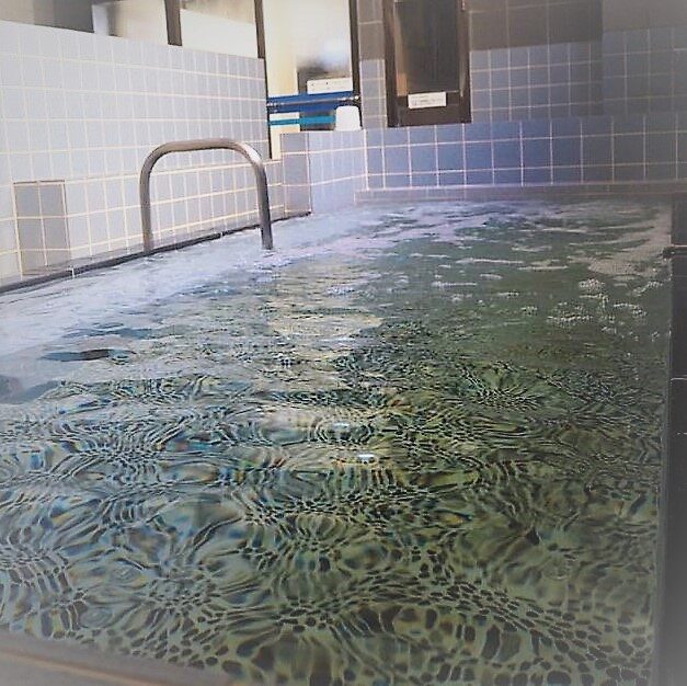 Rippling water in kom-pal tiled indoor bath with a stainless grab bar