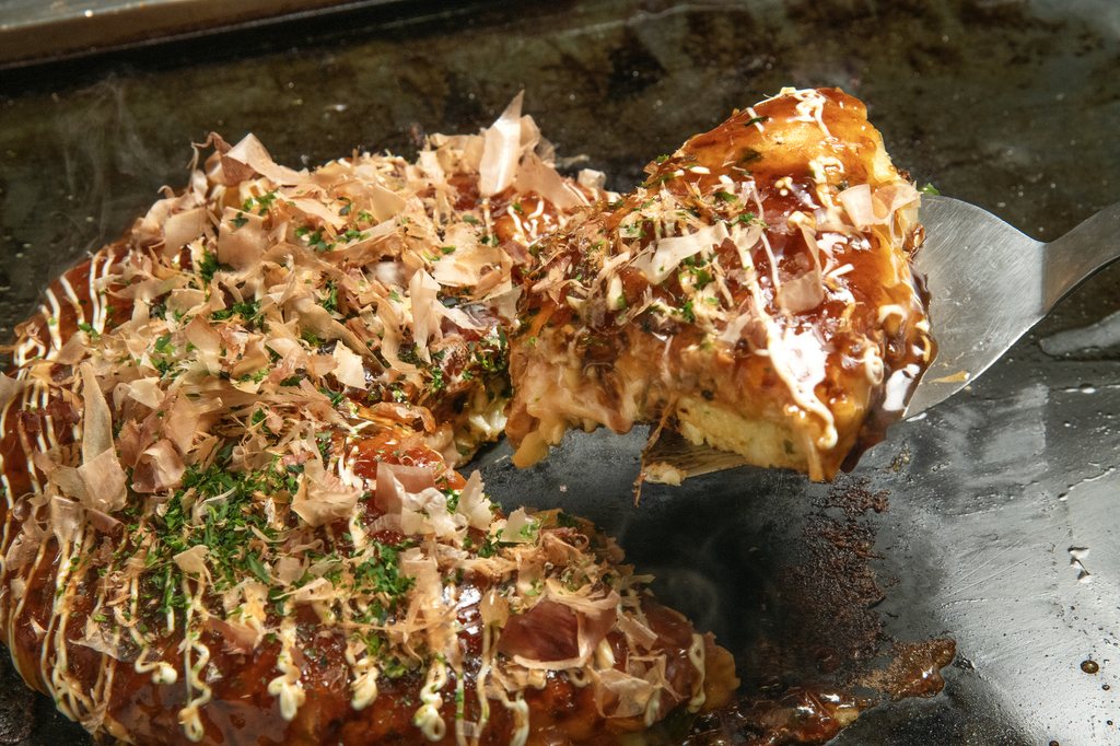 Okonomiyaki cooking on a hot teppan griddle