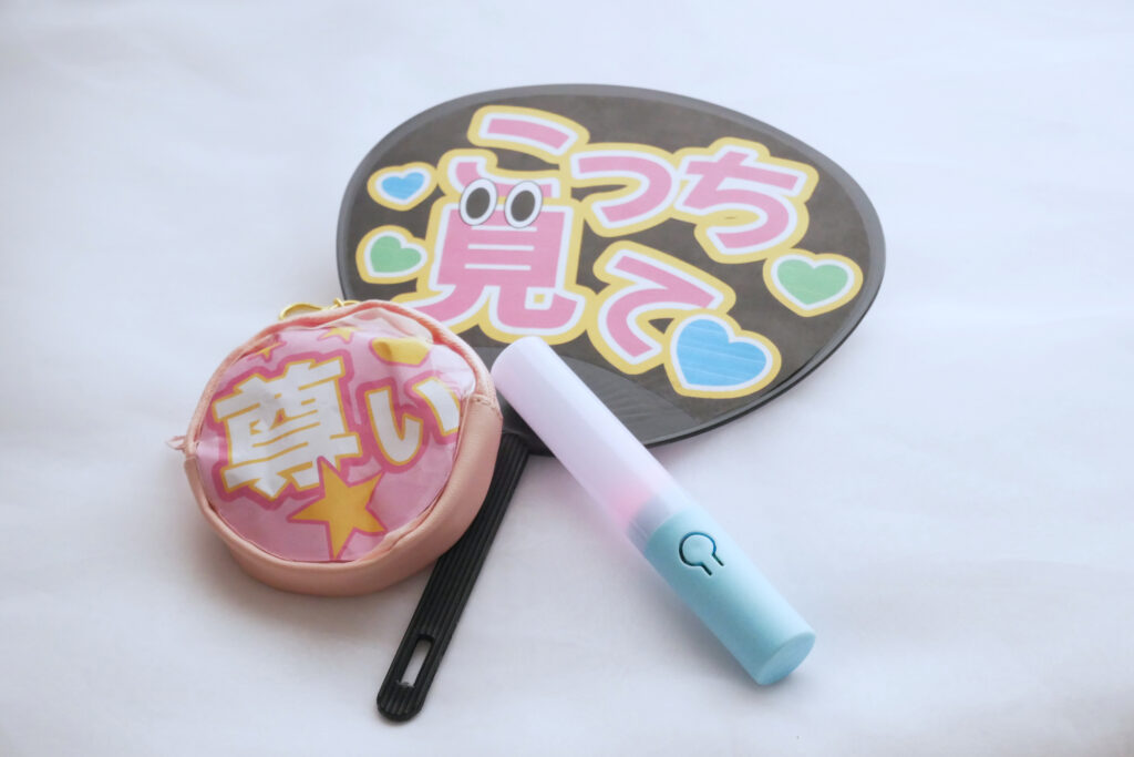 Oshikatsu fan goods on a white surface: a paddle fan reading