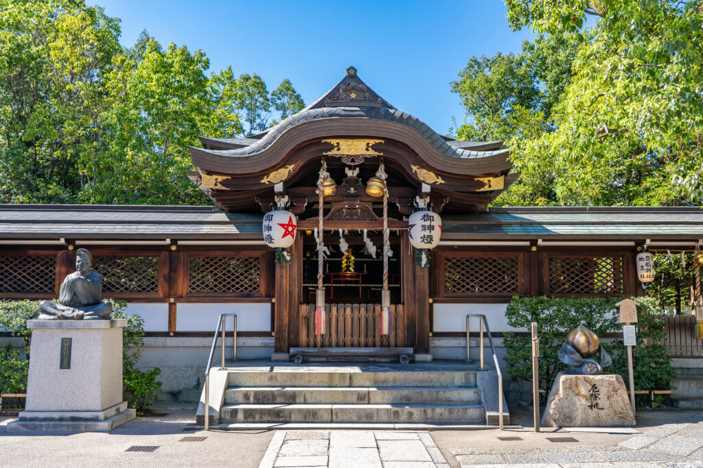 Seimei Shrine's curved-roof hall in Kyoto, hung with white lanterns bearing red pentagrams