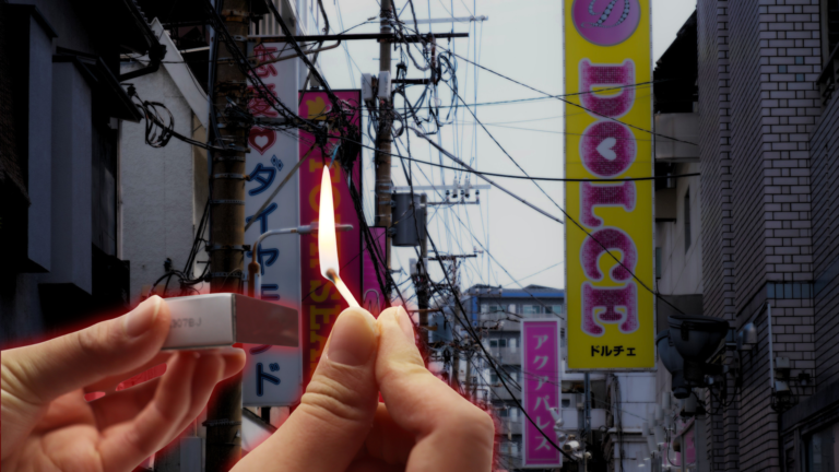 A hand strikes a lit match against a blurred street of pink and yellow Japanese sex-industry signs, including one reading DOLCE.