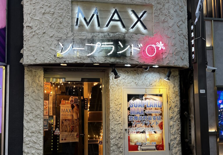 The storefront of a Shinjuku soapland, lit up with neon signage reading “MAX” and “ソープランド” (soapland).