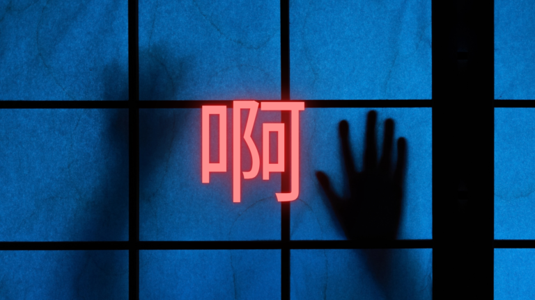 The Chinese character 啊 glowing red over a backlit blue shoji screen, with the shadow of a hand pressed against the paper.