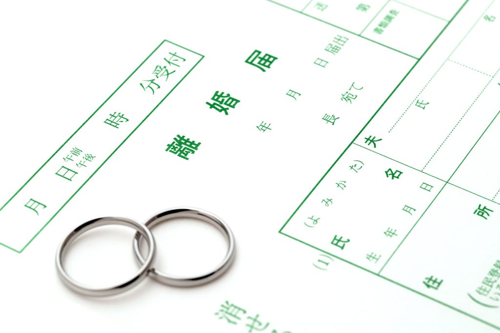 Two wedding rings resting on a blank Japanese divorce registration form (rikon todoke)